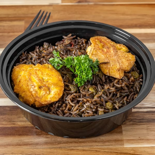 Lakay Buffet's Haitian black rice with two pieces of fried plantain and a sprig of parsley.