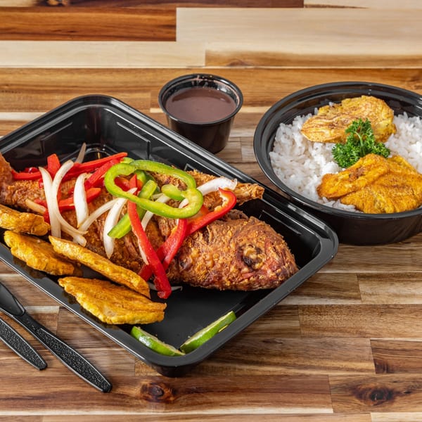 Fried fish with red and green peppers, onions, plantains, rice, and a side of sauce.