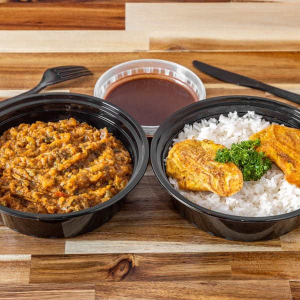 Haitian food in black to-go containers: rice with fried plantains and a stew, plus a side of sauce.